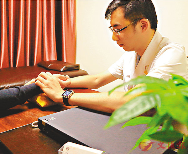 ■李威廷目前擁有內地和香港的醫師執照,現已在廣州冼村某醫館做中醫師。圖為李威廷在接診。 香港文匯報記者胡若璋 攝